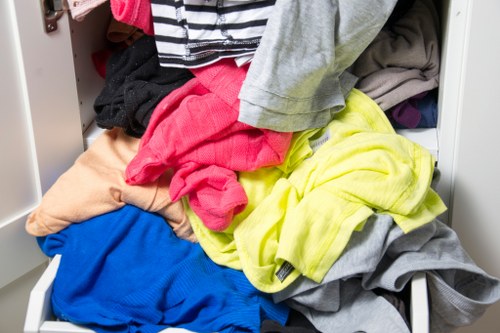 Stacked skips and vans ready for collection in a busy town area